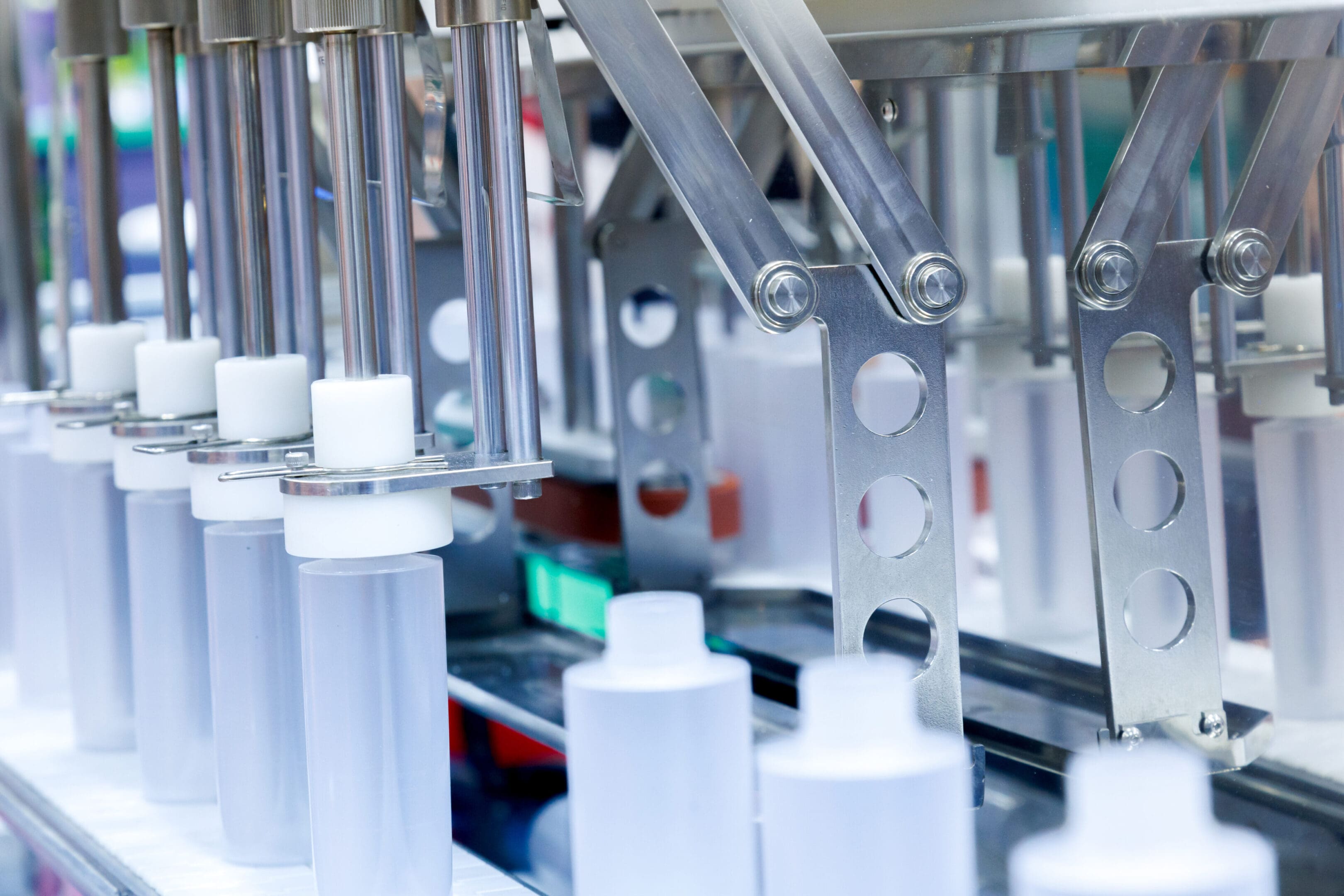 Automatic machinery filling bottles in a production line.