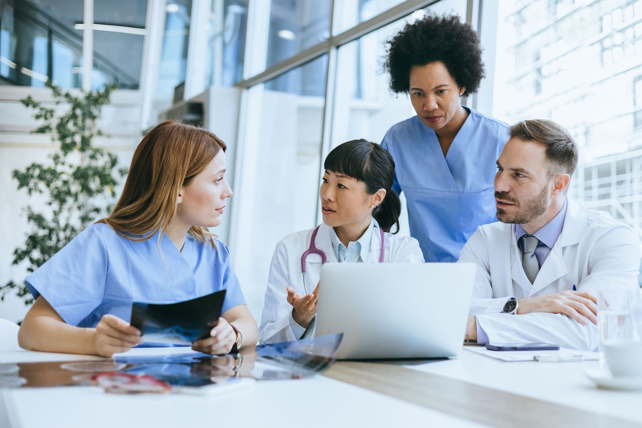 Team collaborating around a laptop in a modern office.