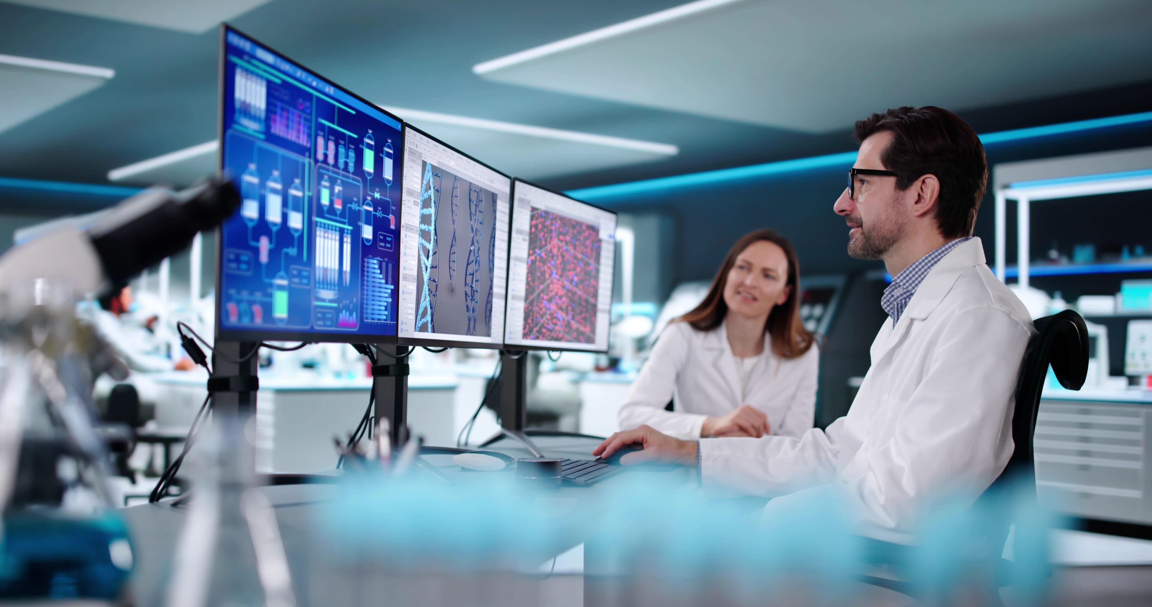 Scientists analyzing data on multiple monitors in a high-tech lab.